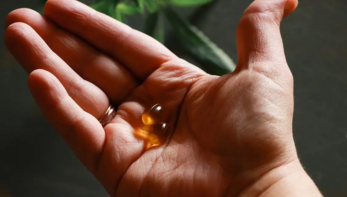 Person holding Medical Cannabis capsules in palm of hand